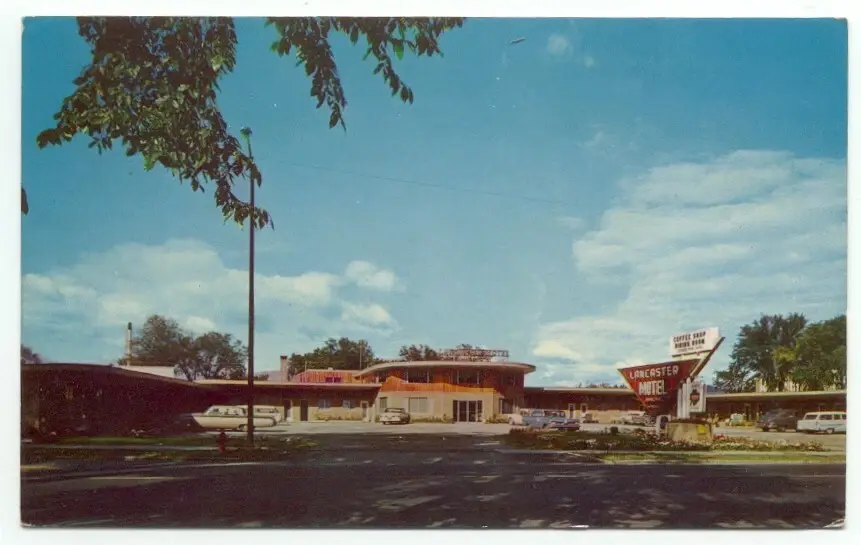 Vintage postcard of The Lancaster Motel from the 1950s — the original property at 112 Main Street with curved entrance and motor court layout
