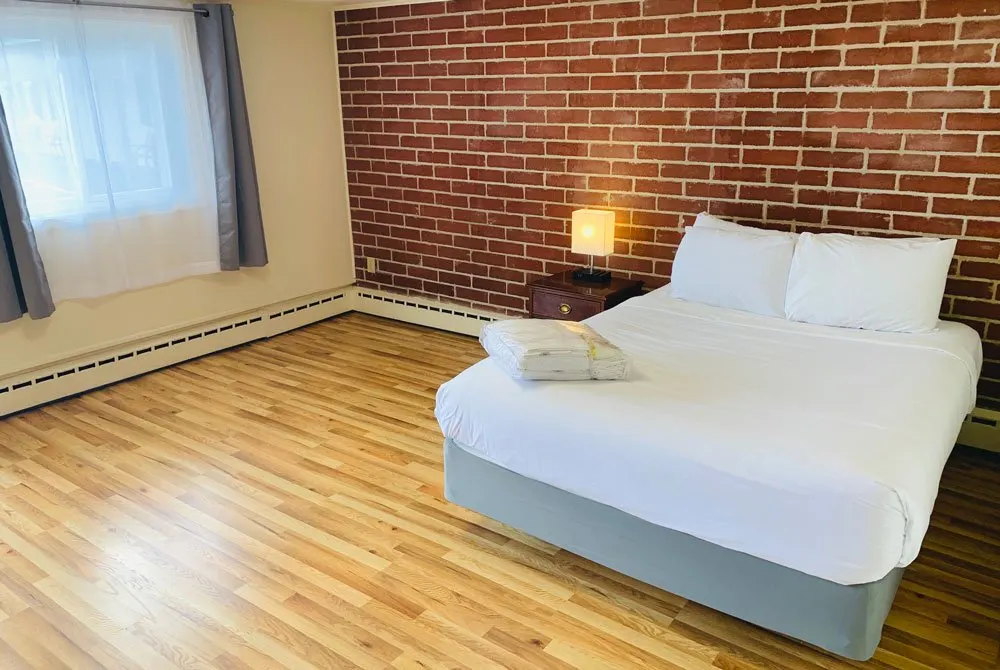 Standard Queen room at Red Fox Inn — one queen bed, light bedding, retro 1955 motor lodge layout